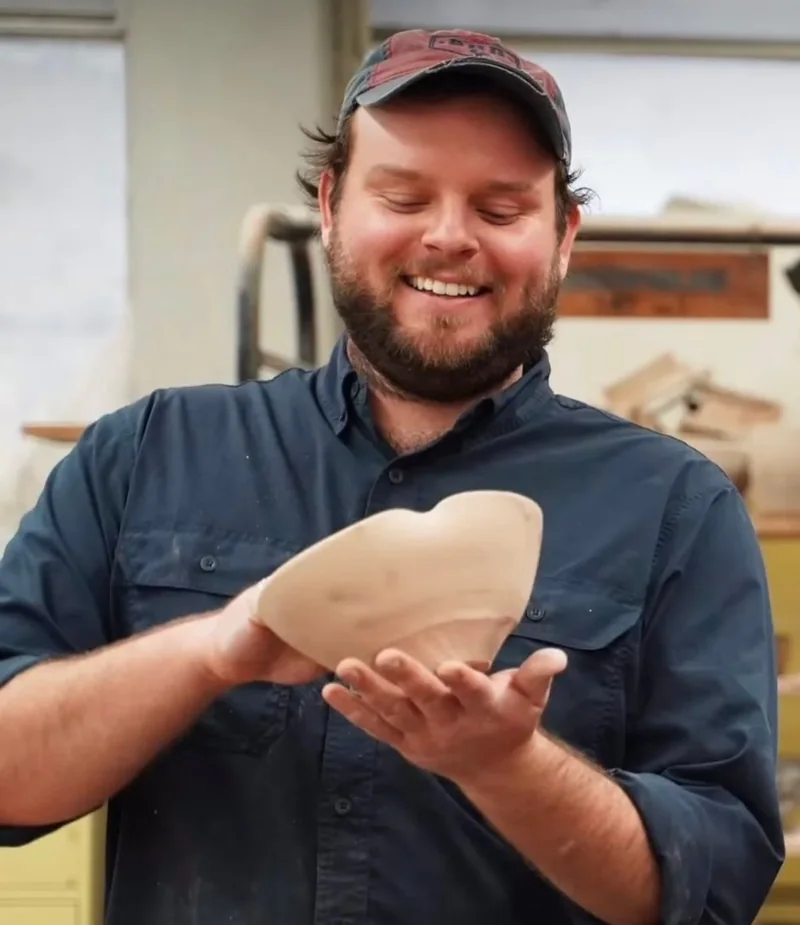 Me smiling in the studio, holding a freshly thrown bowl