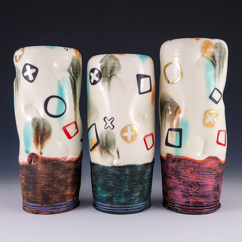 Three tall ceramic vessels with graphic marks and textured bases